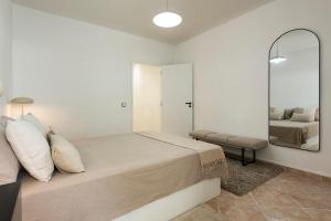 a bedroom with a large bed and a mirror at NUZZA - Vilamoura Marina with BBQ in Vilamoura