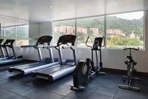 a gym with several tread machines in front of a window at Hampton by Hilton Bogota Usaquen in Bogotá