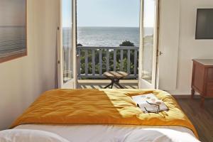 Un dormitorio con una cama con vista al mar. en Hotel Le Bellevue, Demeures & Chateaux, en Villerville