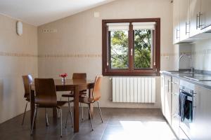 Una cocina con mesa y sillas y una ventana. en Agroturismo Argoin Txiki, en Zarautz