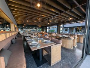 une salle à manger avec des tables et des chaises dans un restaurant dans l'établissement Transit Samui Resort, à Koh Samui  36 autres photos
