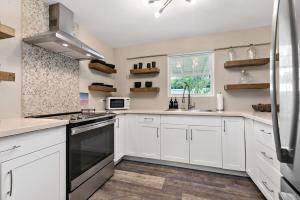 a kitchen with white cabinets and a window at The Queen's Quarters - King Bed - AC - Walkable in Christiansted