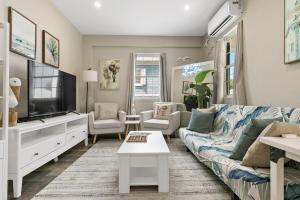 a living room with a couch and a tv at The Queen's Quarters - King Bed - AC - Walkable in Christiansted +30 photos