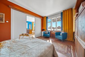 a bedroom with a bed and two blue chairs at Waterfront River Side Roof Top Apartment - Terrace with city view in Prague