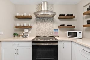 a kitchen with a black stove and a microwave at The Queen's Quarters - King Bed - AC - Walkable in Christiansted