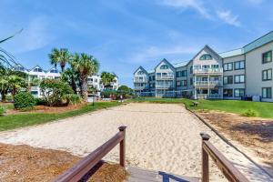 a sandy beach in front of some apartment buildings at Plantation East #1104 in Gulf Highlands