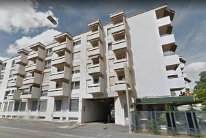 a white building with many windows on a street at VISIONAPARTMENTS Binzmühlestrasse 50 - contactless check-in in Zürich