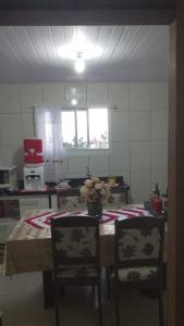 a kitchen with a table with two chairs and a vase of flowers at Alberto in Governador Celso Ramos +7 photos
