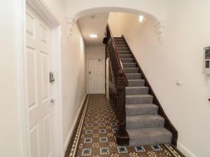 a hallway with a stairway with a door and a staircase at Four in Peterborough
