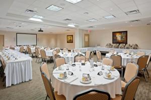 a conference room with tables and chairs and a screen at Holiday Inn Hotel & Suites Surrey East - Cloverdale by IHG in Surrey +107 photos