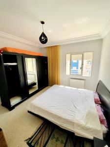 Un dormitorio con una cama blanca grande y una ventana en Luxury apartment 5 minutes from the sea, en Nabeul 25 fotos más