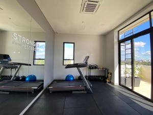 a gym with treadmills and exercise equipment and windows at Stylish 2 Bedroom Apt In Molas Lopez in Colonia Lomas Valentinas