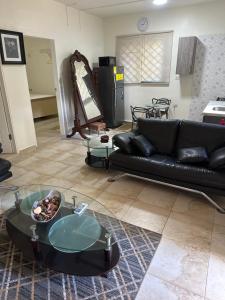 a living room with a black couch and a glass table at Hidden oasis in Mandeville