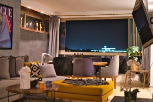 una sala de estar con un sofá y una mesa en Prestigia, superbe appartement, vue sur golf, piscine et Atlas, en Marrakech