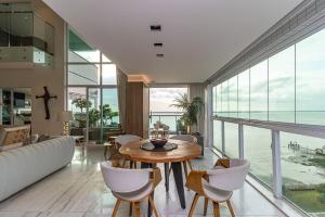 a living room with a table and chairs and the ocean at Ed. Premium in Curro Velho