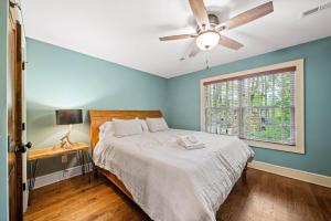 Un dormitorio con una cama con ventilador de techo y una ventana. en Sweet Retreat at Sweetgrass, en Blowing Rock