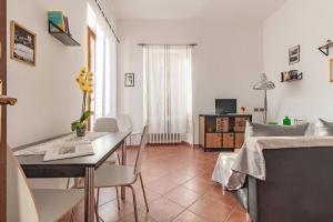 a living room with a table and a dining room at Casa con terrazza panoramica sul lago Maggiore in Maccagno con Pino e Veddasca