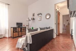 a living room with a couch and a clock on the wall at Casa con terrazza panoramica sul lago Maggiore in Maccagno con Pino e Veddasca