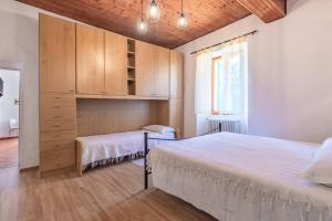 a bedroom with a large bed and a cabinet at Casa con terrazza panoramica sul lago Maggiore in Maccagno con Pino e Veddasca