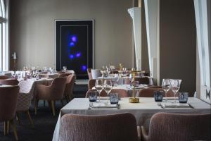 a dining room with tables and chairs with wine glasses at Impérial Palace in Annecy +91 photos