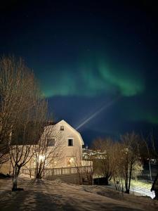 an image of a house with the aurora in the sky at City Serenity Suite in Harstad