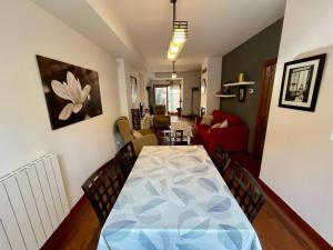 a dining room table with chairs and a living room at Casa exclusiva l Wifi l Garaje l Pool in Biescas