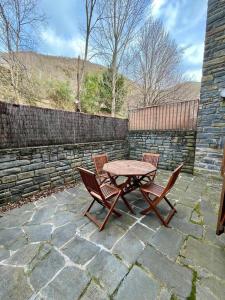 a picnic table and two chairs on a stone patio at Casa exclusiva l Chimenea l Wifi l Garaje l Pool in Biescas