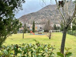 un parco con parco giochi con una montagna sullo sfondo di Casa exclusiva l Chimenea l Wifi l Garaje l Pool a Biescas