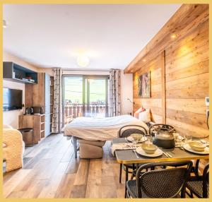 a hotel room with a bed and a table and chairs at La Petite Ourse I Studio meublé Bernex in Bernex