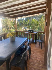 a patio with a table and chairs on a deck at Chez Maya 2 chambres dont suite parentale et 2 salles de bain dans camping 4 étoiles in Saint-Julien-en-Born