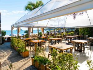 an outdoor patio with tables and chairs and the ocean at Pousada dos Sonhos in Florianópolis
