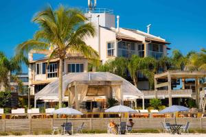 a hotel on the beach with chairs and umbrellas at Pousada dos Sonhos in Florianópolis