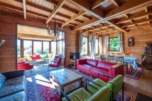 a living room with red couches and a table at Sous le Cielle d'Ardenne in La Roche-en-Ardenne