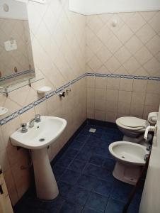 a bathroom with two toilets and a sink at Hotel posada sol in Villa Carlos Paz