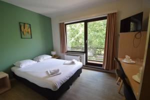 a bedroom with a bed and a large window at Budget Flats Brussels in Brussels