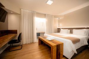 a bedroom with a large bed and a wooden table at Pousada dos Sonhos in Florianópolis +126 photos
