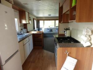 cocina pequeña con fogones y sofá en Delightful Caravan With A Lake View At Southview Holiday Park Ref 33026Cl, en Winthorpe