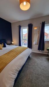a bedroom with a large bed and a window at Stylish 2-bedroom home in Salford - 5 guests in Manchester