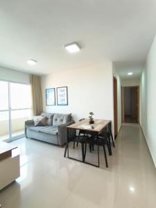 a living room with a couch and a table at Espaço Aruba l Apê confortável perto da Praia in São Luís