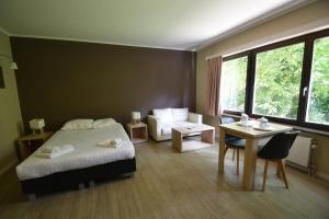 a bedroom with a bed and a couch and a table at Budget Flats Brussels in Brussels