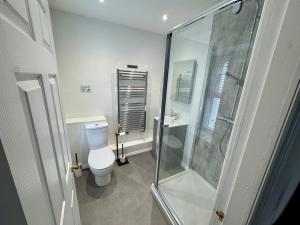 a bathroom with a toilet and a glass shower at Camellia Cottage With Garden in Bowness-on-Windermere