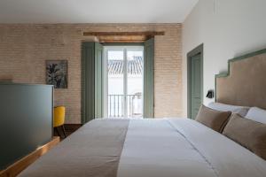 a bedroom with a large bed and a television at Apartamentos Gravina 31 in Seville