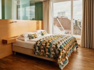 a bedroom with a bed and a large window at Hotel Ploberger in Wels +47 photos