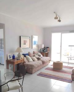 a living room with a couch and a glass table at Jávea Beachfront Penthouse in Platja de l'Arenal