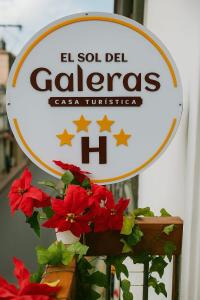 a sign for a callez casa tucinas with red flowers at HOTEL EL SOL dEL GALERAS in Pasto