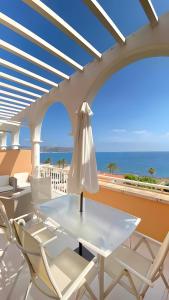 a white table and chairs on a balcony with the ocean at Jávea Beachfront Penthouse in Platja de l'Arenal