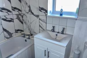 ein Badezimmer mit einem Waschbecken, einer Badewanne und einem Waschbecken in der Unterkunft 2 Bed House-Sleeps 4-Free Parking in Coseley