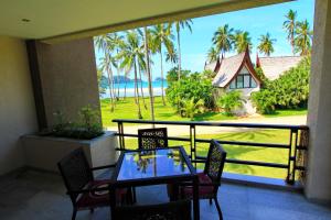 a balcony with a table and chairs and a view of the ocean at Chang Noi Paradise Apartments in Ko Chang