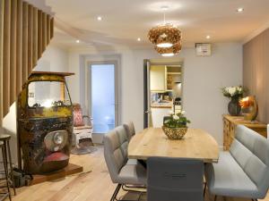 a dining room with a table and a gold chandelier at Riversdale in Grasmere
