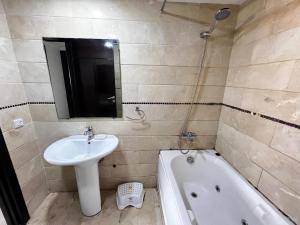 a bathroom with a sink and a mirror and a tub at Corniche Casablanca in Casablanca +10 photos